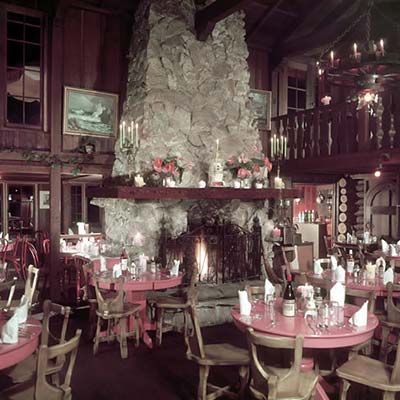 Historic interior dining room at Shadowbrook Restaurant with rustic wood and stone details.