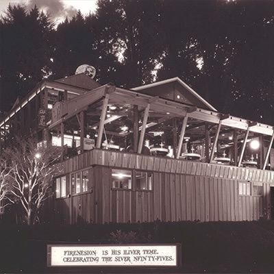 alt="A vintage black-and-white photograph of Shadowbrook Restaurant in its early years, showing the original timber structure and hillside gardens overlooking Soquel Creek.